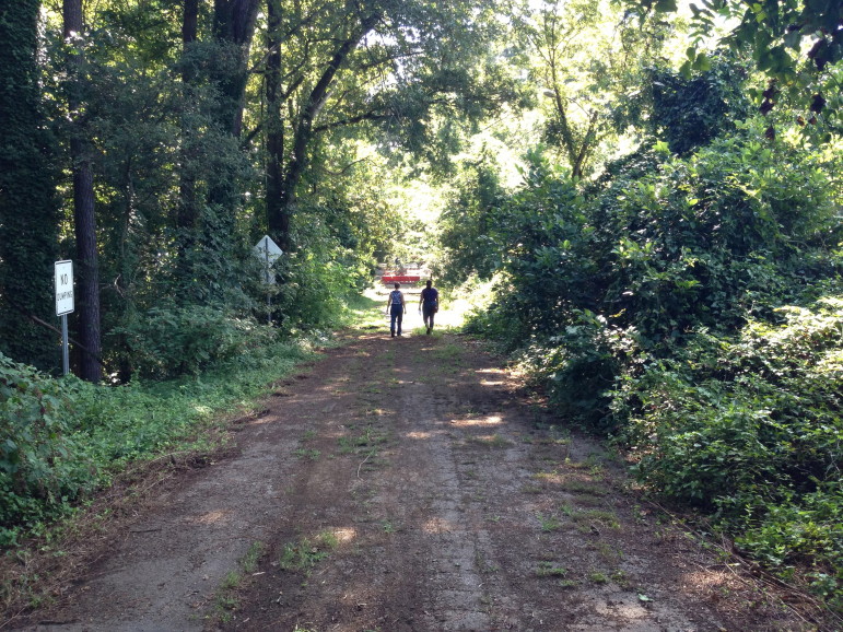File: October 2013. Reporter Ariella Monti and Gloria Putnam walk down the closed portion of Albemarle Drive at the east end of the Longview Lake Dam.