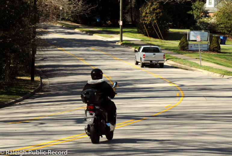 A man rides a motor bike on a section of Dixie Trail near Wade Avenue. 