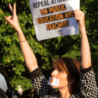 Anca Stephan of Cary, with mouth covered with a sticker declaring North Carolina school teachers are 46th in the country when it comes to salaries.