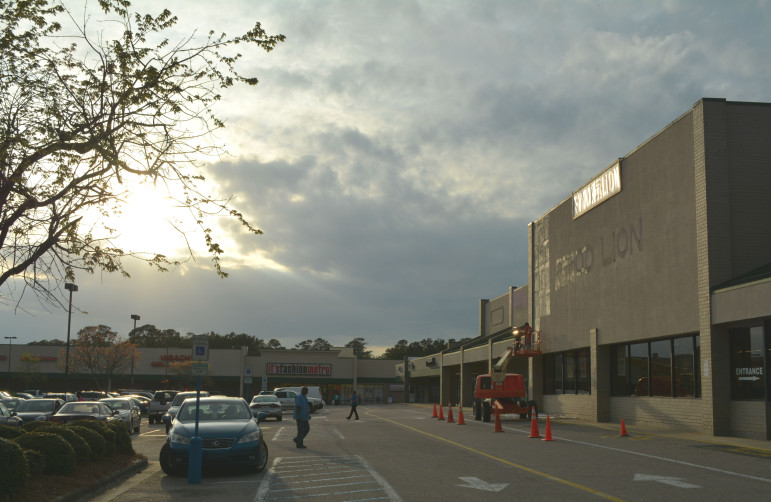 Workers change out the sign at a Food Lion at Capital Square off Capital Boulevard