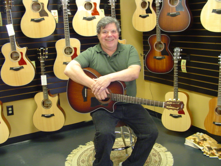 Harry Tuering sitting in his guitar shop