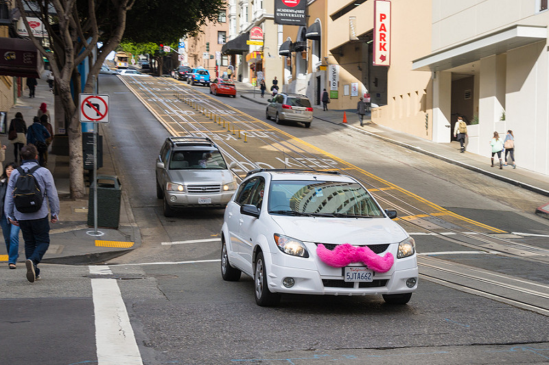 white car with pink mustache on front Lyft driver