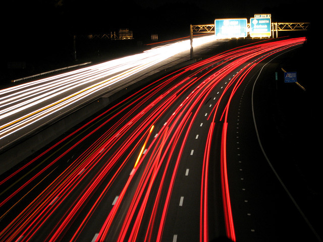 red and white trails formed by lights at night on the interstate