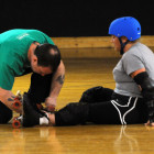 Rollergirl's coach Cody Pendant, left, helps one of the women trying out with her skate. During the tryout, one of her wheels came off.