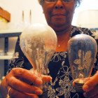 Edna Rich-Ballentine holds two Pope House light bulbs with the original filaments still intact.